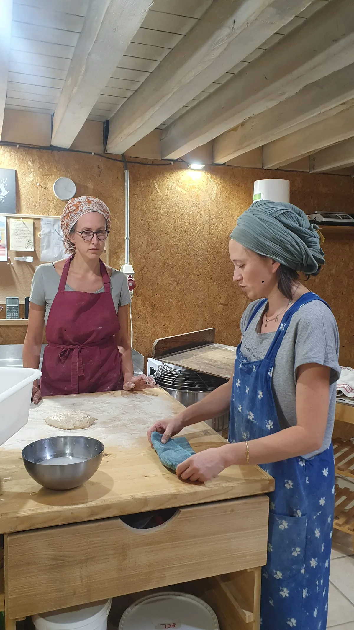 Aline et Tania au façonnage, autour du plan de travail en bois du fournil