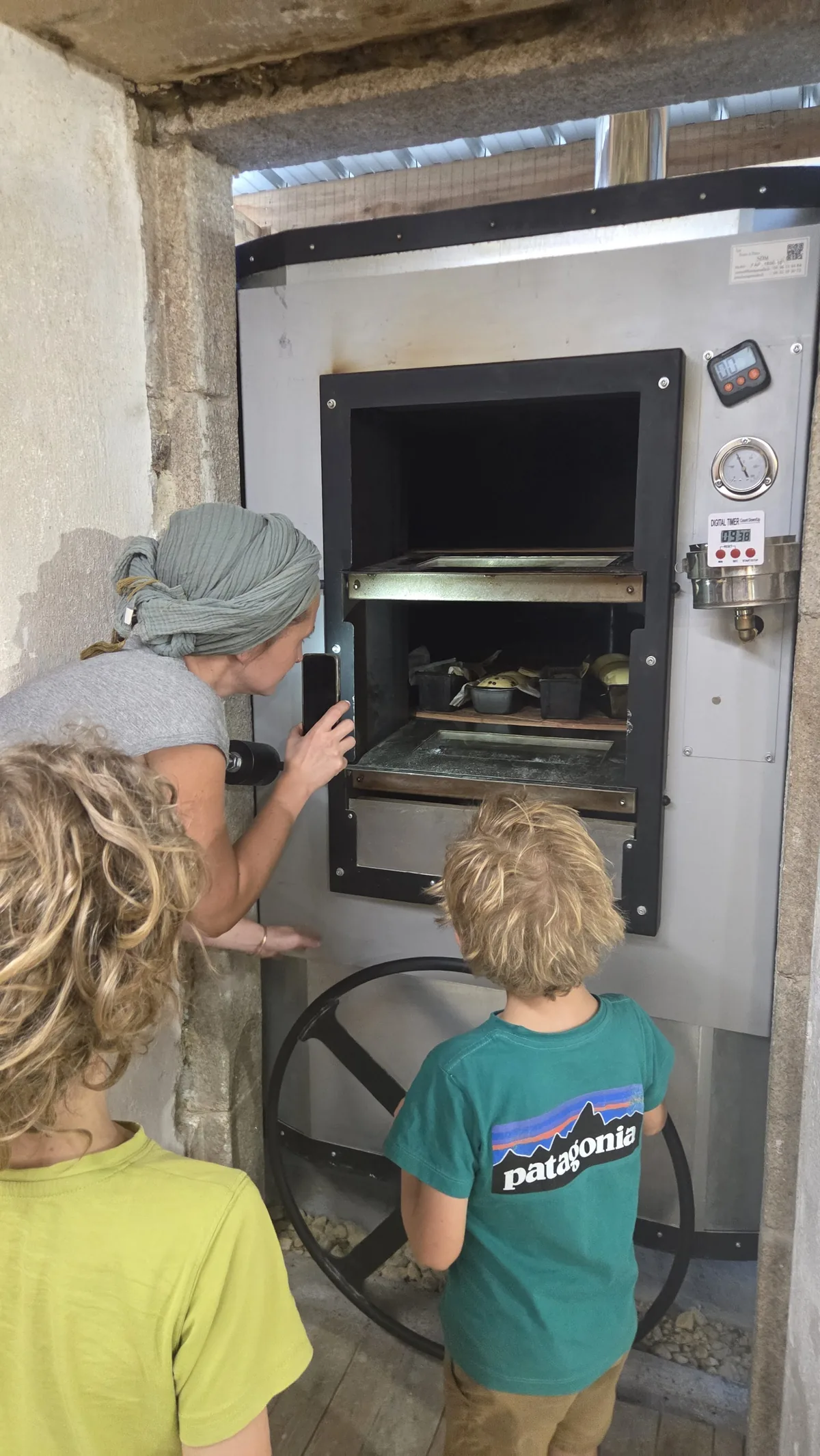 Tania montrant aux enfants l'intérieur du four à bois et ses deux soles
