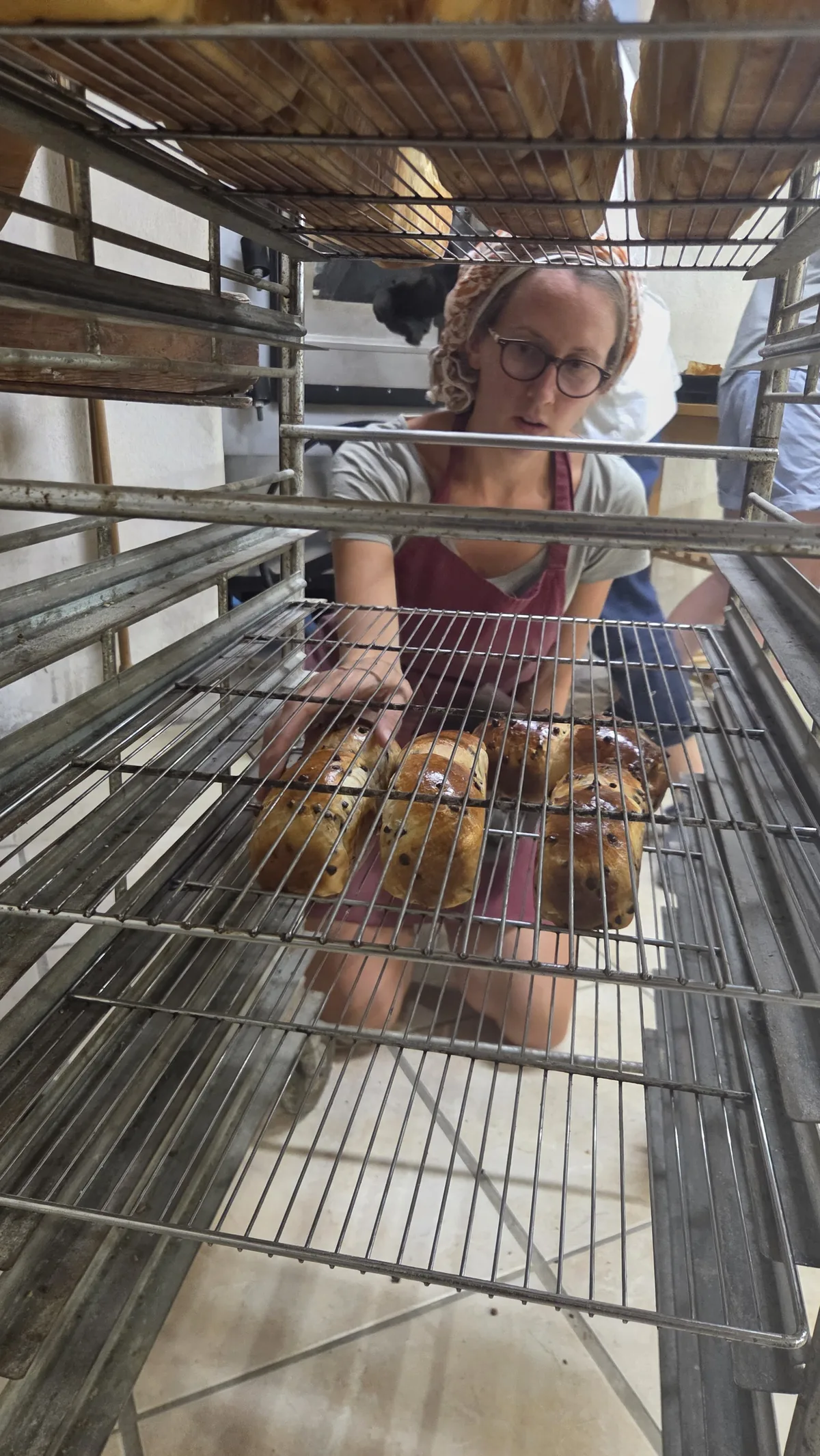 Tania rangeant les pains cuits sur les échelles à pain du fournil